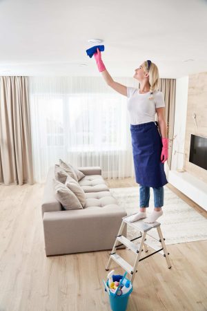 full-length-woman-standing-sofa-home