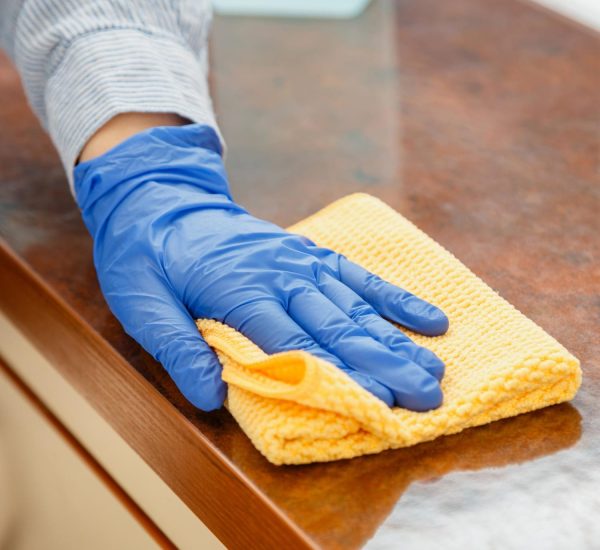 woman-wiping-table-countertop-kitchen-by-wet-cloth-rag-female-charwoman-hand-cleaning-disinfect-office-home-restaurant-surfaces-close-up