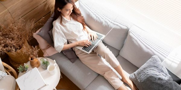 young-attractive-asian-female-working-home-hand-use-laptop-checking-search-schedule-working-process-planning-report-with-leisure-relax-sofa-living-room-with-morning-light-peaceful-moment