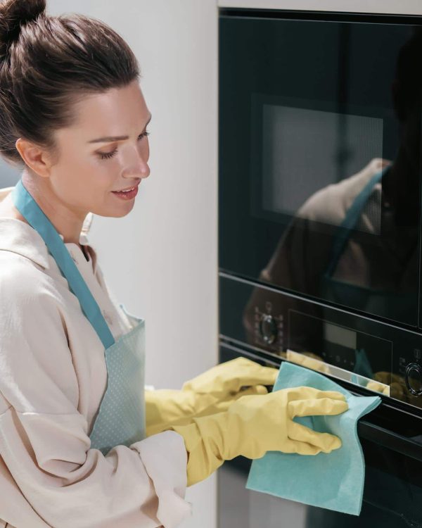 young-dark-haired-woman-cleaning-kitchen-appliances